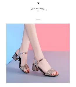 Détail de sandales dorées à talons blocs avec brides ornées de strass brillants