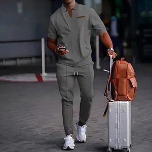 Detail of men's grey waffle knit short sleeve polo and matching trousers travel set