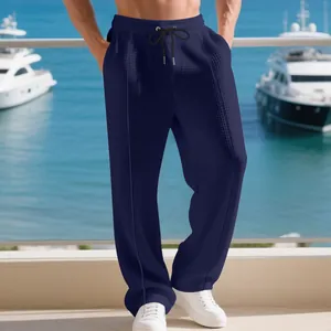 Detail view of men's navy blue waffle knit straight leg casual trousers on a model.