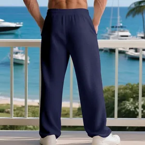 Back view of men's waffle texture casual pants in a seaside resort setting