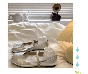 Gros plan sur des ballerines Mary Jane argentées pour fille avec chaussettes à volants