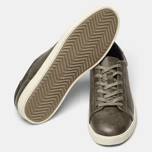 Dettaglio di sneaker marroni da uomo con tomaia testurizzata e suola in gomma ondulata