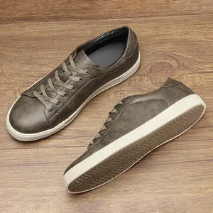Dettaglio di sneaker basse da uomo verde vintage su sfondo in legno naturale.