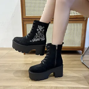 Seitenansicht schwarzer Plateau-Stiefeletten mit elegantem weißem Blumenstickerei-Design