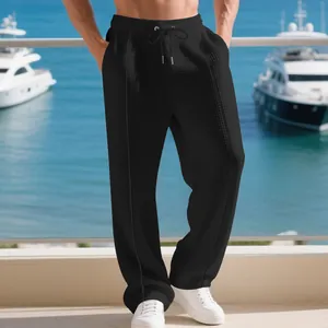 Close-up of black waffle knit texture on men's straight-leg casual sports trousers.