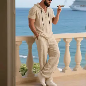 Men's casual beige linen hooded Henley shirt and matching pants set in a vacation setting.
