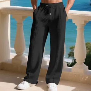 Detailed view of black waffle knit fabric on men's loose straight leg trousers.