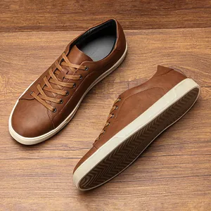 Vista dettagliata dall'alto e laterale di classiche sneakers basse in pelle marrone da uomo