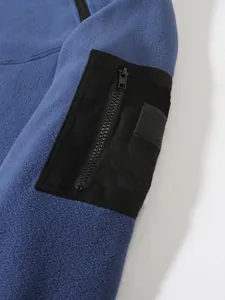 Gros plan sur la poche zippée noire de la manche d'une veste en polaire bleue
