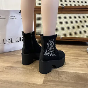 Detailansicht der schwarzen Plateaustiefel mit Stickerei und seitlichem Reißverschluss.