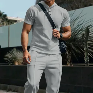 Detail of men's grey waffle knit two-piece set featuring hooded neckline and buttons.