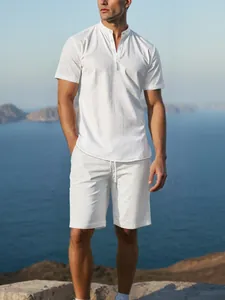 Detailed view of men's white cotton linen Henry collar shirt and shorts set on seaside cliff