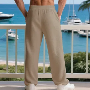 Detailed back view of men's beige waffle textured casual pants with a loose straight leg fit