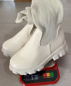 Detail showing a single beige knit patchwork boot weighing 578g on a digital scale