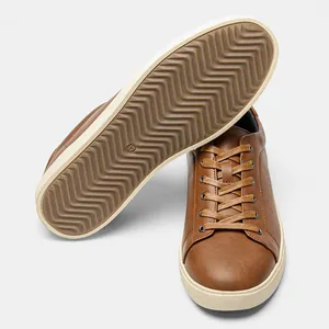 Vista dettagliata di sneaker marroni da uomo con suola ondulata antiscivolo e tomaia