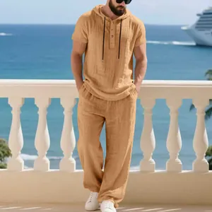Men's casual linen hooded Henley shirt and matching loose pants shown in seaside setting