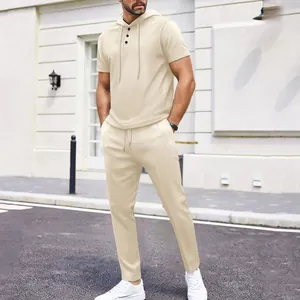 Casual men's beige waffle knit two-piece hooded top and trousers set in urban street view