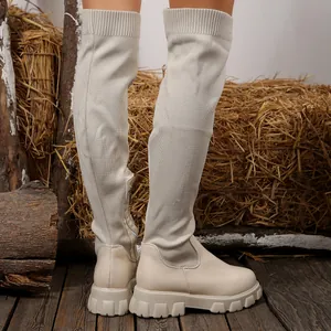 Detailed view of cream over-the-knee boots with knit and leather patchwork design