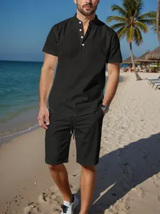 Men's black cotton linen Henley shirt and shorts set styled on a sunny summer beach scene