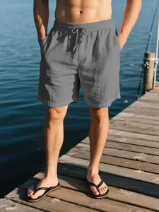 Pantalones cortos de playa en lino gris para hombre con cordón en un muelle de madera