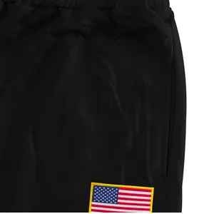 Close-up of black men's joggers showing drawstring waist and US flag patch detail