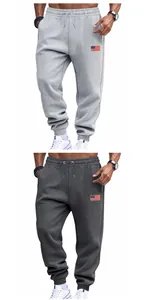 Detail of men's loose drawstring sweatpants in grey and dark grey with flag patch