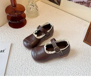 Detailed view of brown children's Mary Jane leather shoes with delicate white lace trim