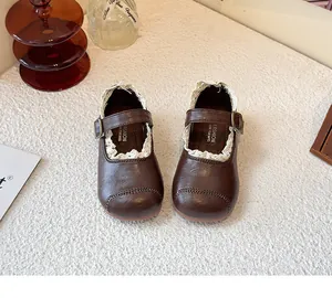 Top-down view of brown girls' princess shoes featuring elegant white eyelet lace trim.