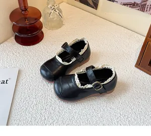 Detailed top-down view of girl's black leather shoes with white lace trim details