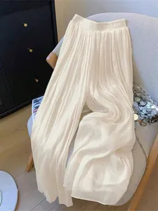 Elegant cream colored high-waisted pleated wide-leg trousers for a casual vacation look
