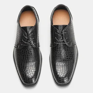 Vista dall'alto di scarpe eleganti da uomo nere con motivo a coccodrillo e lacci.