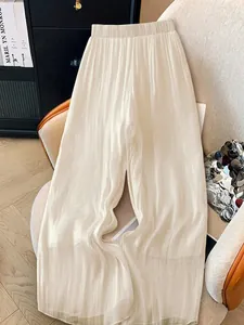 Close-up detail of cream pleated wide-leg trousers with vertical texture for women