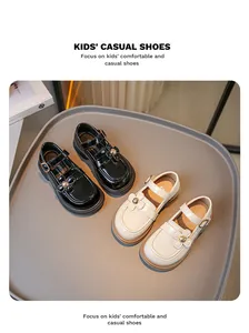 Detailansicht von britischen Leder-Kinderschuhen in Schwarz und Creme mit Blumendekor
