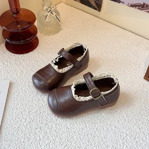 Vintage dark brown girl princess shoes with white lace trim and buckle strap details.