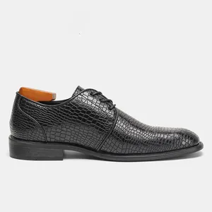 Vista laterale di scarpe business da uomo in pelle nera con motivo a coccodrillo