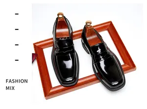 Detail showing the glossy patent leather and square toe of the black loafers