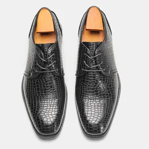Vista dall'alto di scarpe eleganti da uomo in pelle nera con stampa coccodrillo e tendiscarpe