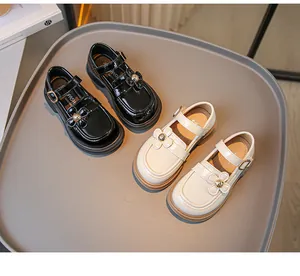 Detailaufnahme von Mädchen-Loafers aus Lackleder im britischen Stil mit Blumenakzenten