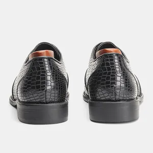 Vista posteriore dettagliata di scarpe eleganti da uomo nere con trama a coccodrillo