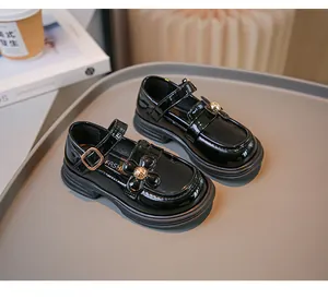 Detailansicht von Mädchen Mary Jane Schuhen aus schwarzem Lackleder mit Blumendetail
