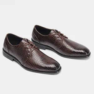 Vista dettagliata di scarpe eleganti da uomo marroni con trama di coccodrillo