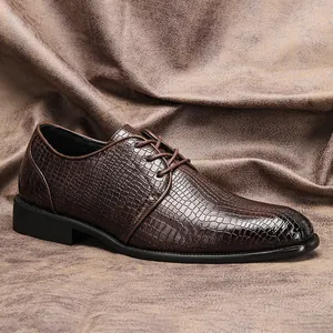 Dettaglio scarpa elegante da uomo marrone con trama a coccodrillo e chiusura stringata