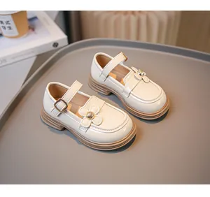 Detailansicht eleganter weißer Lacklederschuhe für Mädchen mit Blumendekor.