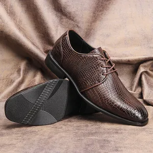 Dettaglio di scarpe da uomo in pelle marrone con motivo a coccodrillo e suola antiscivolo