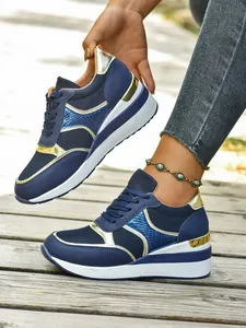 Λεπτομερής άποψη μπλε και χρυσών sneakers πλατφόρμας με πλέγμα και σχέδιο με κορδόνια