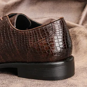 Dettaglio ravvicinato di una scarpa business da uomo in pelle marrone con trama coccodrillo