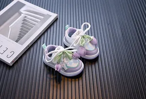 Primer plano de zapatillas para niñas pequeñas con lindos adornos de tulipanes en 3D.