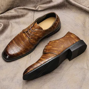 Primo piano della trama a coccodrillo marrone su scarpe eleganti da uomo da lavoro.