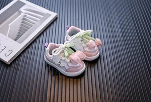 Detalle de zapatillas rosa y blanco para niñas con decoraciones de tulipanes de seda
