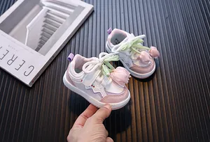 Vista detallada de zapatos rosa para niña con suela blanda y adorno de tulipa